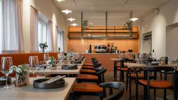 Restaurant à l'aménagement moderne avec cuisine ouverte et tables élégamment dressées