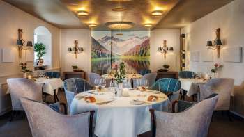 Salle de restaurant élégante avec des tables dressées avec goût, une ambiance raffinée et un grand paysage