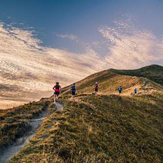 Groupe de coureurs de trail sur une crête près de Malbun, Liechtenstein, dans la lumière du soir
