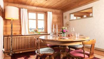 Salle à manger confortable avec des boiseries, une table ronde et un intérieur rustique