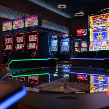 Vue de la zone moderne des machines à sous du Casino Admiral Triesen, avec ses machines à sous à l'éclairage coloré.