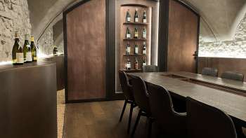 Elégante salle de dégustation du WY Weinbar avec plafond voûté et table en bois noble pour des dégustations de vin exclusives.