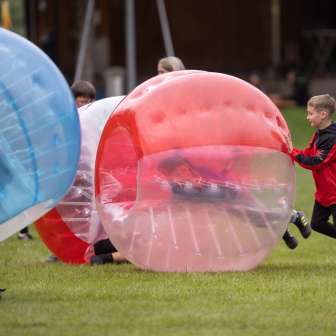 Des enfants jouent au bubble soccer en plein air : du plaisir et de l'action lors d'une aventure en plein air au Liechtenstein