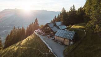 Photo panoramique d'un refuge de montagne isolé au Liechtenstein avec vue sur la vallée du Rhin et technologie solaire sur le toit