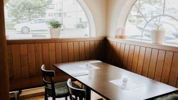 Salle de restaurant accueillante avec des fenêtres claires et un mobilier en bois rustique