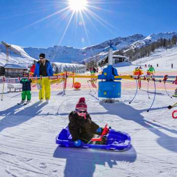 Journée d'hiver ensoleillée au Malbi-Park de Malbun - jeux, divertissement et plaisirs de la luge pour toute la famille au paradis de la neige du Liechtenstein.