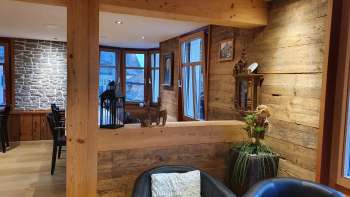 Intérieur accueillant avec des murs en bois, un coin salon élégant et un éclairage naturel