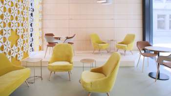 Café moderne avec des fauteuils jaunes élégants, un décor minimaliste et des fenêtres lumineuses Café moderne avec des fauteuils jaunes élégants, un décor minimaliste et des fenêtres lumineuses