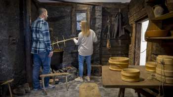 Les visiteurs explorent une ancienne cuisine à fumée au musée Walser de Triesenberg