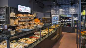 Pains, gâteaux et pâtisseries fraîchement cuits dans la boulangerie moderne Mündle à Ruggell, avec un comptoir de vente accueillant.