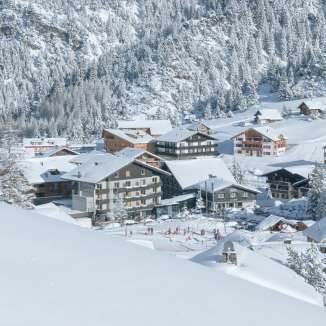 Paysage hivernal enneigé dans la station de ski de Malbun au Liechtenstein, avec vue sur le village et les versants de montagne environnants.