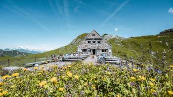 Randonneurs sur le chemin du refuge Pfälzerhütte, dans un environnement alpin.