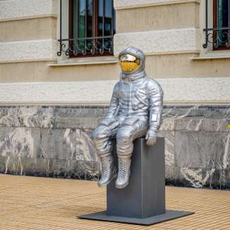 Vue latérale d'une sculpture d'astronaute argentée avec une visière dorée à l'exposition Bad Ragartz à Vaduz