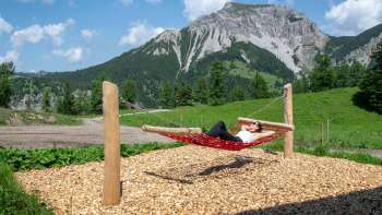 Une femme se détend sur un hamac le long du sentier des balançoires.
