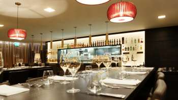 Bar moderne dans le restaurant Kokon avec des verres à vin élégants et un éclairage d'ambiance