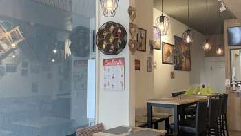 Salle de restaurant aménagée avec style, avec des meubles en bois noir, des sols en bois et des décorations murales créatives