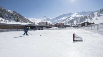 Vaste patinoire à Malbun devant un impressionnant décor de montagnes et sous un soleil radieux