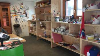 Intérieur du magasin Birkahoflädile avec des étagères en bois remplies de produits régionaux, décorées avec des éléments colorés - magasin à la ferme au Liechtenstein.