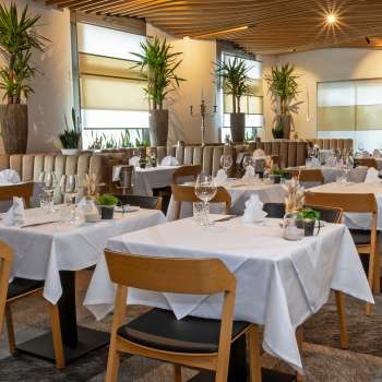 Vue sur le restaurant Alpspitz, aménagé avec style, avec des tables nappées de blanc et une atmosphère moderne et lumineuse.