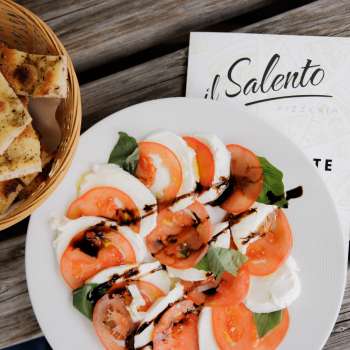 Pizza fraîche à la sauce tomate et à la roquette, servie sur une table rustique en bois