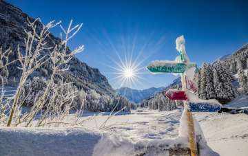 Des panneaux indicateurs enneigés et un paysage hivernal de rêve sous un soleil éclatant Steg , Liechtenstein.