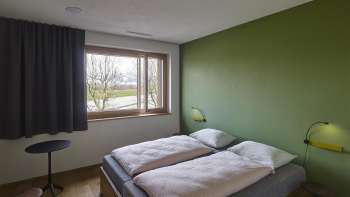 Chambre double avec un mur peint en vert à l'auberge de jeunesse de Schaan-Vaduz