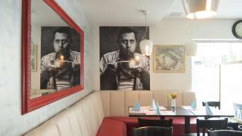 Coin salon confortable au restaurant Made in Italy une fresque murale élégante et un miroir rouge