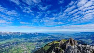 Vue lointaine du sommet les Trois Sœurs sur la vallée du Rhin et le Liechtenstein - décor alpin impressionnant avec croix et vue lointaine