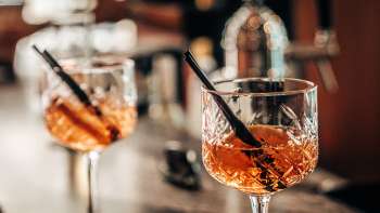 Deux verres à apéritif avec des tranches d'orange sur le bar