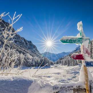 Des panneaux indicateurs enneigés et un paysage hivernal de rêve sous un soleil éclatant Steg , Liechtenstein.
