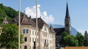  Vue à travers un arc en plein cintre sur le quartier du gouvernement à Vaduz avec le bâtiment du parlement régional et la cathédrale St Florin.