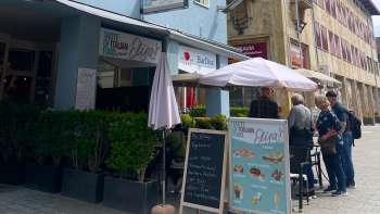 Vue extérieure du restaurant Elisas avec parasols et menu sur le tableau noir Vue extérieure du restaurant Elisas avec parasols et menu sur le tableau noir