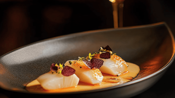 Plat artistiquement présenté sur une assiette noire Plat artistiquement présenté sur une assiette noire