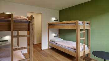 Chambre quadruple avec lits superposés et parquet à l'auberge de jeunesse Schaan/Vaduz
