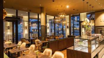 Café élégant avec des sièges confortables, des meubles élégants et une ambiance lumineuse chaleureuse