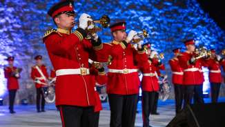 Ensemble de fanfares en uniformes rouges voyants lors du Princely Tattoo 2022 au Liechtenstein - représentation festive avec des sons traditionnels.