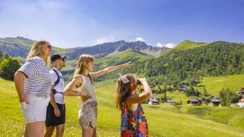 Famille regardant au loin dans le paysage alpin avec vue sur les montagnes en été