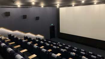 l'écran de cinéma du Skino Schaan, avec des rangées de sièges confortables au design sombre.