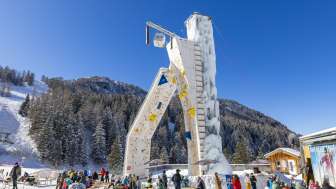 Les plaisirs de l'hiver à la tour de glace de Malbun La tour d'escalade glacée de Malbun entourée d'hôtes hivernaux dans un décor alpin - un point fort pour les amateurs de sports d'hiver au Liechtenstein.
