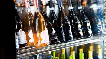 Réfrigérateur à vin bien fourni avec une sélection de vins rouges, blancs et rosés en Dolce Gusto