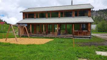 Photo extérieure du Malbipark-Bistro avec une aire de jeux et une prairie au premier plan