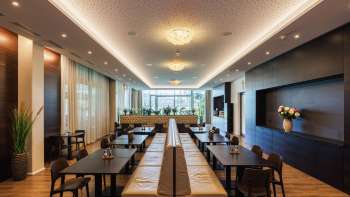 Salle à manger lumineuse du restaurant Kommod avec un design élégant et de grandes fenêtres.