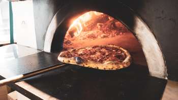 Pizza au feu de bois aux bords dorés et à la croûte croustillante Pizza au feu de bois aux bords dorés et à la croûte croustillante