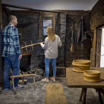 Les visiteurs explorent une ancienne cuisine à fumée au musée Walser de Triesenberg