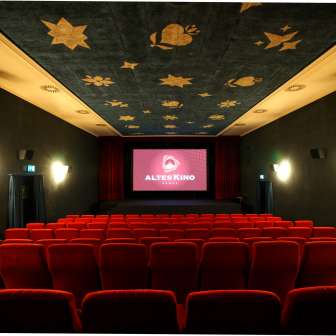 Intérieur de l'ancien cinéma de Vaduz avec sièges rouges et plafond décoré