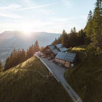 Photo panoramique d'un refuge de montagne isolé au Liechtenstein avec vue sur la vallée du Rhin et technologie solaire sur le toit