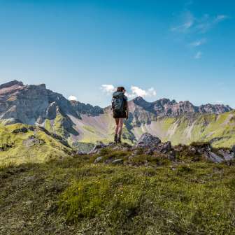 Randonneuse sur un sommet au Liechtenstein avec vue sur une impressionnante chaîne de montagnes - été, liberté et nature à l'état pur