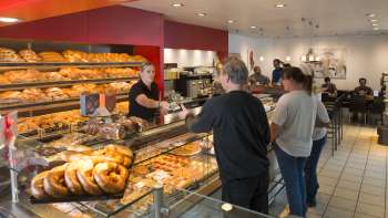Espace de vente dans la boulangerie-pâtisserie Mündle à Mauren dans lequel les gens achètent du pain Espace de vente dans la boulangerie-pâtisserie Mündle à Mauren dans lequel les gens achètent du pain