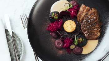 Repas servi avec style sur une assiette noire au Chapter Two