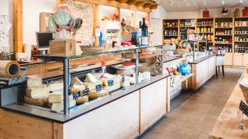 Salle de vente moderne du magasin de la ferme Bangshof au Liechtenstein avec des produits régionaux tels que du fromage, du yaourt et des fruits.
